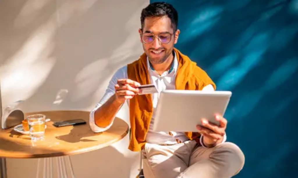 Man looking at card and holding tab in hand