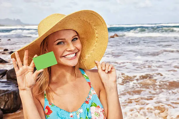 Person a beach holding a loyalty card as part of her travel rewards plan